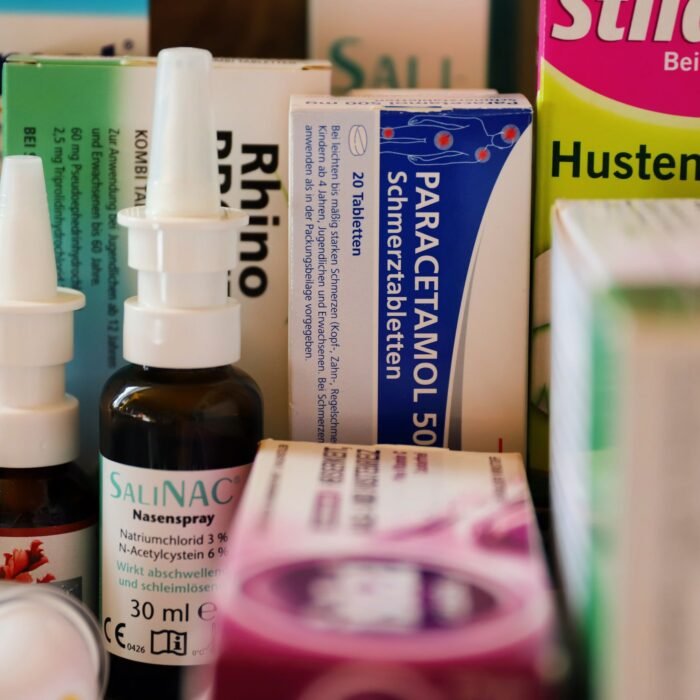 Assortment of cold and flu medications on a pharmacy counter.